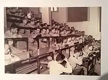  photo prise dans le grand amphithéâtre où l'on voit les jeunes médecins en uniforme assis sur les bancs attendant leur tour pour descendre à l'estrade choisir leur premier poste