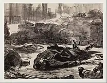 Lithographie présentant, devant une barricade, le cadavre allongé sur le dos d'un homme en tenue militaire. Les pieds d'un autre défunt apparaissent en bas, à droite de l'image.