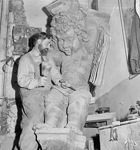 Le sculpteur néerlandais Maarten Mooij (nl), en 1964, opérant un travail de finition à l'aide d'un maillet, sur un ange en bois destiné à la Nouvelle église d'Amsterdam.