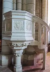 Photographie d'une chaire en pierre blanche et de son escalier d'accès.