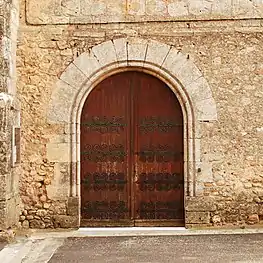 Porte cintrée ornée de pentures.