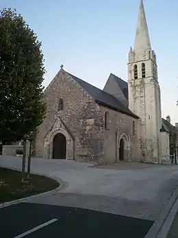 Vue générale de la nef et du clocher en pierre d'une église.