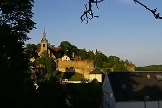 Vue de l'église et des anciennes murailles. En bas à droite, la salle des fêtes (bâtiment de la mairie).