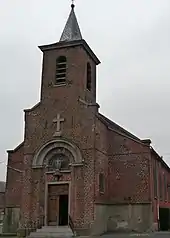 Photo en couleurs représentant une église semi-classique en briques rouge foncé.