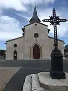 Photographie du pignon d’une église, avec une croix monumentale en premier plan.