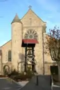 La cloche de l'église est suspendue à l'extérieur.