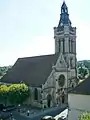 L'église, depuis le château. On aperçoit la première baie gothique du bas-côté nord, de 1300 environ.