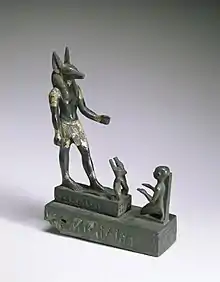 Statuette en bronze montrant un adorateur agenouillé devant Anubis.