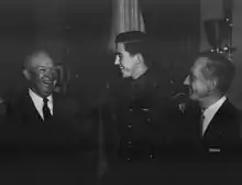 Photographie noir et blanc montrant trois hommes d'âges différents riant.