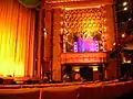 grane salle de spectacle avec un balcon et des rideaux tendus