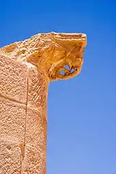 haut d'une colonne prise en contre-plongé d'une sculpture stylée d'un éléphant dans le grès rouge. Fond de ciel bleu.