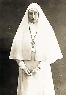 photographie noir et blanc d'une femme en habit blanc de religieuse.