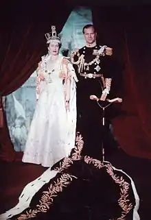 Élisabeth portant une robe et une couronne aux côtés de son époux en uniforme militaire.