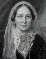 Portrait noir et blanc. Jeune femme en buste de face, coiffée d'un voile de mousseline portant collerette en dentelle.