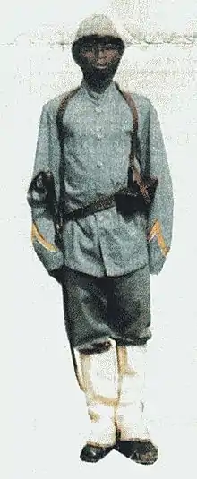 Photographie d'un soldat, de couleur de peaux noir, en uniforme et au garde-à-vous.