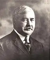 Portrait en noir et blanc d'un homme avec une moustache.