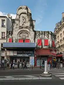 photo de la façade d'un bâtiment dont le grillage de l'entrée est baissé.