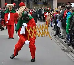 Un streckschere,  en anglais également appelé lazy tongs, avec une structure articulée comme un pantographe, est un objet utilisé par les participants pour taquiner les spectateurs ou attraper leurs casquettes et leurs chapeaux, et parfois pour distribuer des bonbons et autres petits cadeaux.