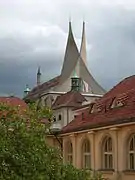 La toiture moderne de béton gris d'un édifice ancien, en forme de deux pointes entrelacées et pointées vers le ciel.