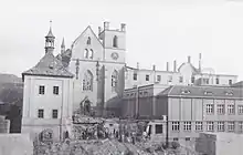 Photographie en noir et blanc d'une église gothique dont le toit est ruiné.