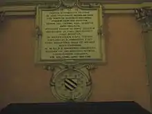 Plaque de marbre portant une texte gravé en latin.