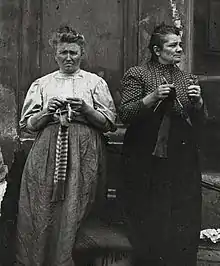 Employées de maison au chômage occupant par le tricot leur temps d'attente d’une nouvelle place, photographiées par Emil Mayer à Vienne (Autriche) entre 1905 et 1914.