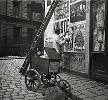 Colleur d’affiche dans les rues de Vienne en Autriche, photographié par Emil Mayer au début du XXe siècle.