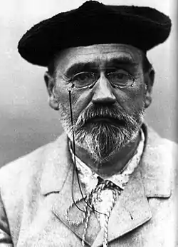 Portrait photographique en noir et blanc d'un homme âgé, portant béret et lorgnons, barbe courte et moustache.