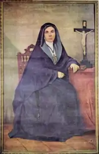 portrait d'une religieuse assise, à côté d'un crucifix