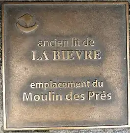 Plaque au sol rappelant l'emplacement du Moulin des Prés, au croisement avec la rue Pape.