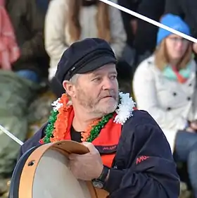 Dans le chenal des Sables-d'Olonne, en buste, barbu, coiffé d'une casquette de marin, il frappe un bodhrán, tambour sur cadre irlandais.