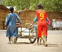 Enfants transportant des sacs.