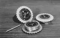 Trois rotors de la machine Enigma et l'axe sur lequel ils sont assemblés.