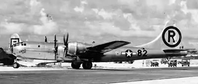 Photographie en noir et blanc de l'avion au sol après sa mission à Hiroshima.