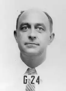 Photo en noir et blanc. Visage d'un homme chauve portant une chemise et une cravate.