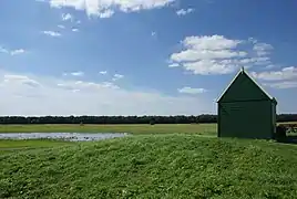 Photographie en couleurs d'une maison entourée par des prés