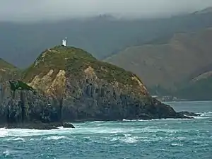 Photographie couleur d'un cap battu par la mer.