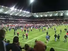 Pelouse d'un stade envahie de spectateurs