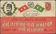 Carte postale révolutionnaire en l'honneur d'Enver Bey. Slogan en français :  « Vive la Patrie - Vive la Nation. Vive la Liberté », 24 juillet 1908
