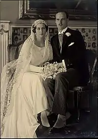 Photographie noir et blanc d'un couple de mariés,  l'homme portant un smoking noir et la femme une robe blanche avec un voile.