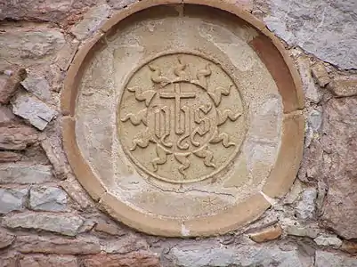 Sceau de saint Bernardin de Sienne sur le mur extérieur.