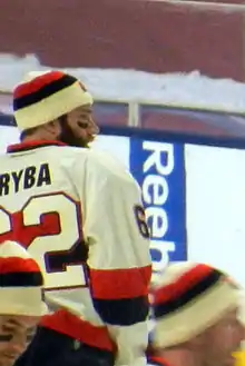 Portrait d’un hockeyeur en équipement, de dos, tournant la tête vers la droite