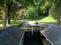 Le lavoir couvert entre la chaussée et le parc ; vue sur le premier tableau du Grand Parc.