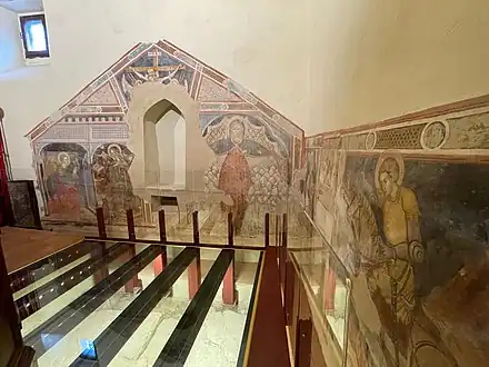 Plancher dégagé sur le premier oratoire de 1420, fresques avec à droite saint Crescentien.