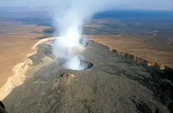 Photographie aérienne d'un volcan fumant.