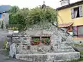 Un monument avec abreuvoir fleuri surmonter d'une croix