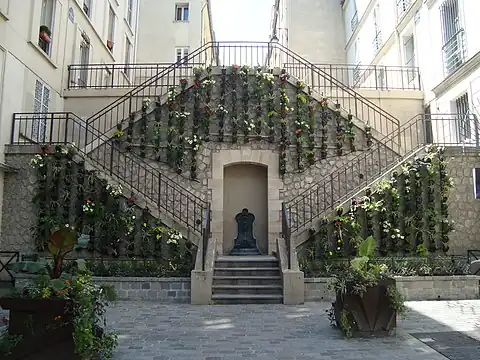 L'escalier fleuri de la rue et sa fontaine murale.