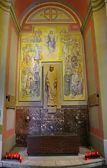 Photo en couleurs d'un autel devant une statue du bienheureux À entourée d'une fresque sur sa vie