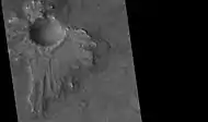 Un cratère à piédestal (HiRISE), Quadrangle de Casius. L'éjecta est asymétrique autour du cratère parce que l'astéroïde a percuté le sol avec un angle faible, venant du nord est.