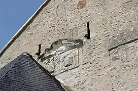 Photographie en couleurs de bas-reliefs représentant des personnages enchâssés dans un mur.